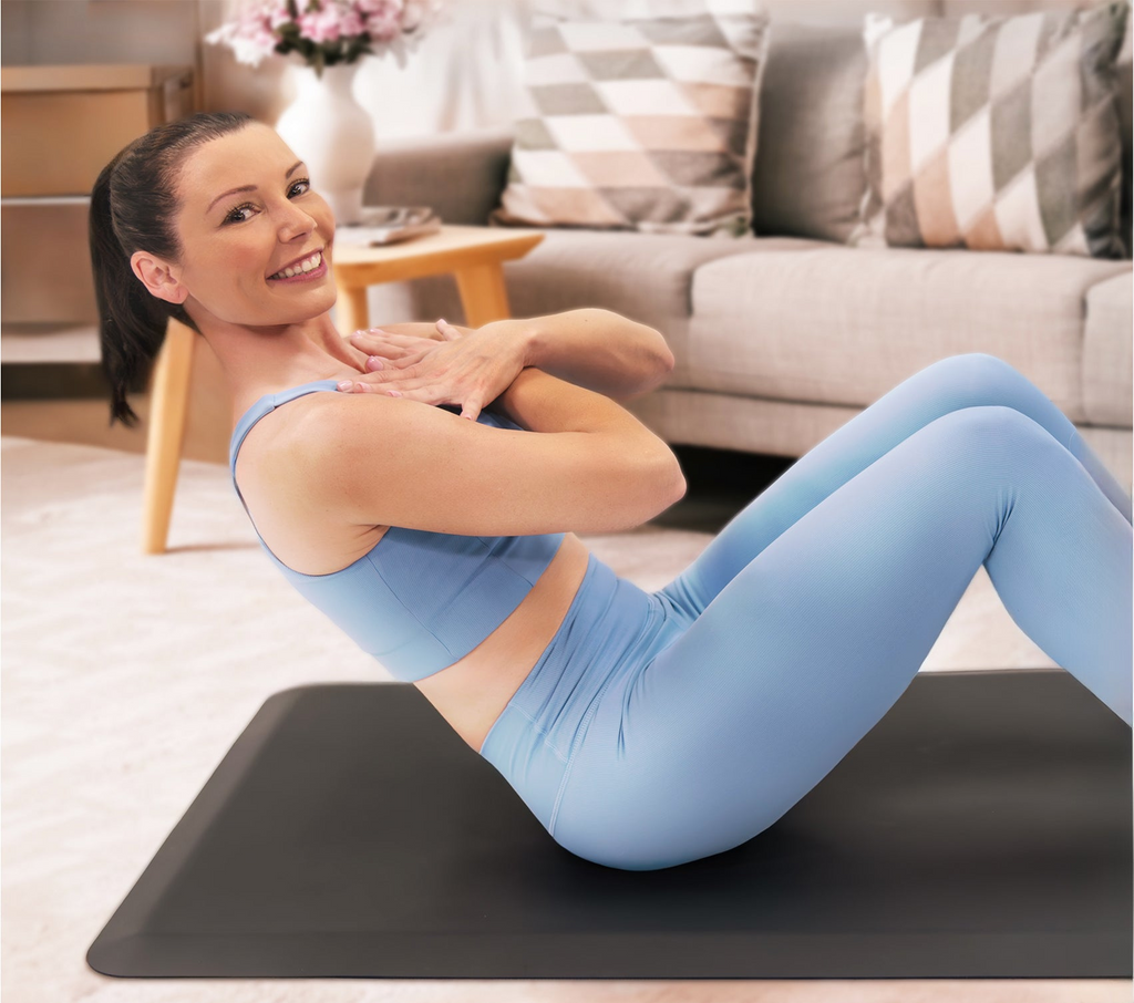 Woman Smiling doing sit-ups on a FitnessMat in her living room 